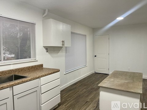 A kitchen with white cabinets and a granite countertop.