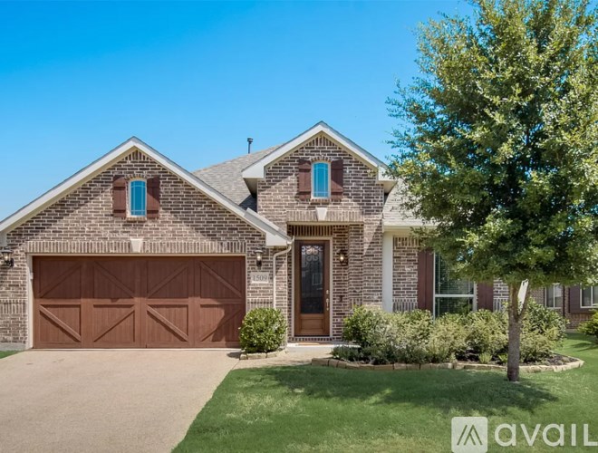 A house with a brown garage door and a tree in front.