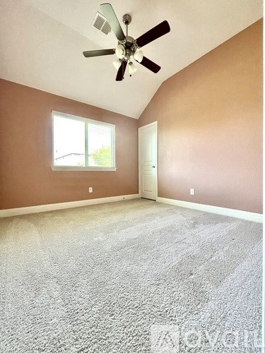 A room with a ceiling fan and a window.