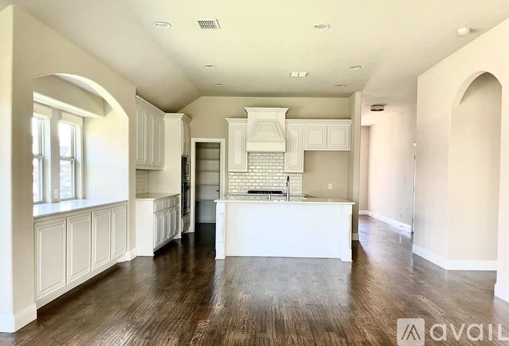 A spacious kitchen with white cabinets and a central island.