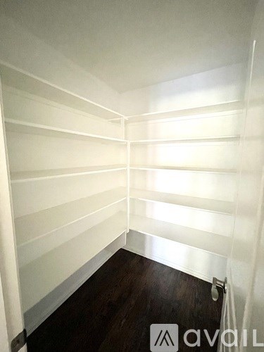 A room with white shelves and a wooden floor.