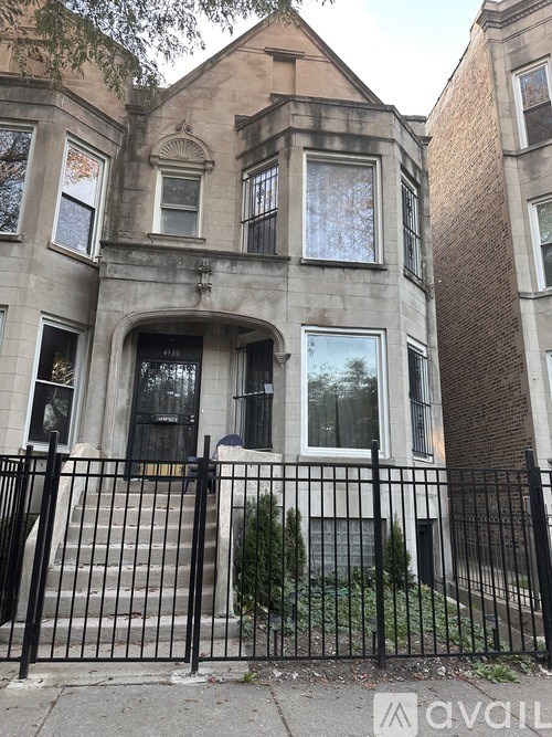 A large house with a black fence in front.