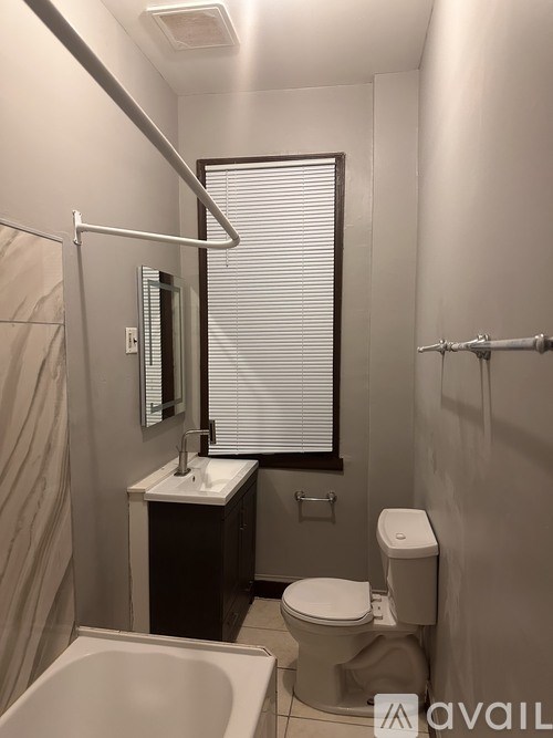 A bathroom with a toilet, sink, and bathtub.