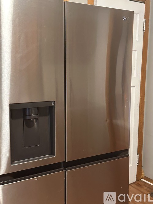 A stainless steel refrigerator with a water dispenser in the door.