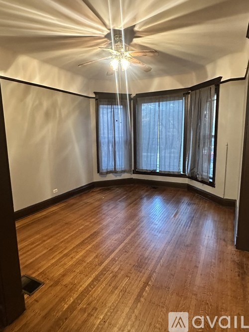 A room with wooden flooring and a ceiling fan.