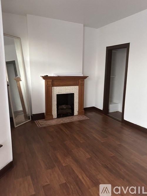 A room with a fireplace and wooden floors.
