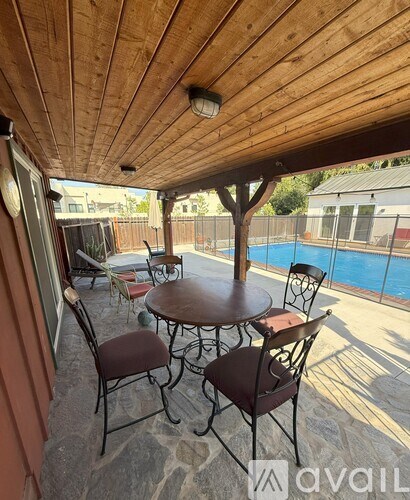 A wooden table with chairs is set up on a patio.