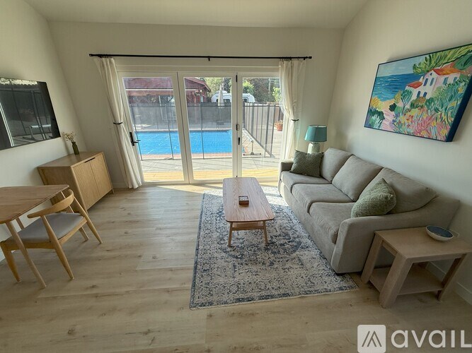 A living room with a pool outside the window.