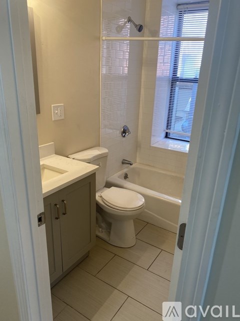 A bathroom with a toilet, sink, and shower.