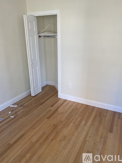 A room with a white door and a shelf in it.