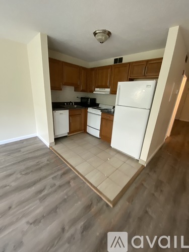 A kitchen with white appliances and wooden cabinets.