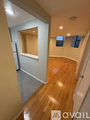 A hallway with wooden floors and a mirror on the wall.
