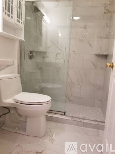 A white toilet in a bathroom with marble tiles.