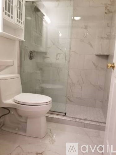 A white toilet in a bathroom with marble tiles.