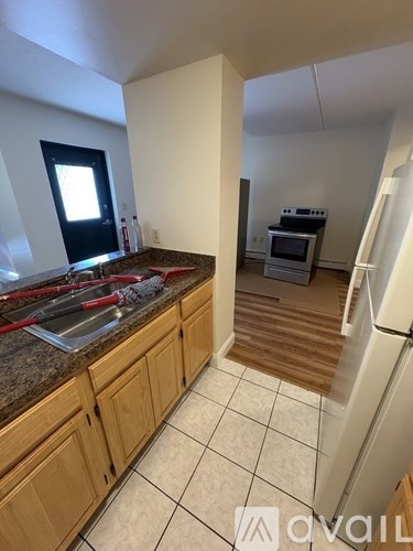 A kitchen with wooden cabinets and a white fridge.