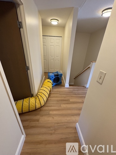 A hallway with a yellow and black striped tube on the floor.