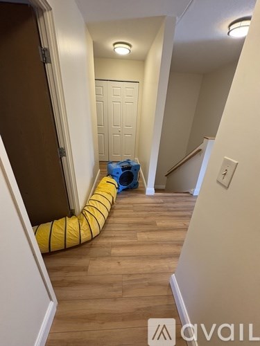 A hallway with a yellow and black striped tube on the floor.