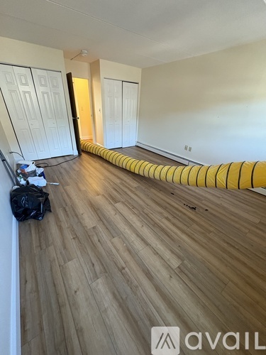 A room with wooden flooring and a yellow striped carpet.