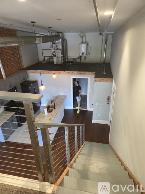 A man is standing in a doorway in a room with a staircase.