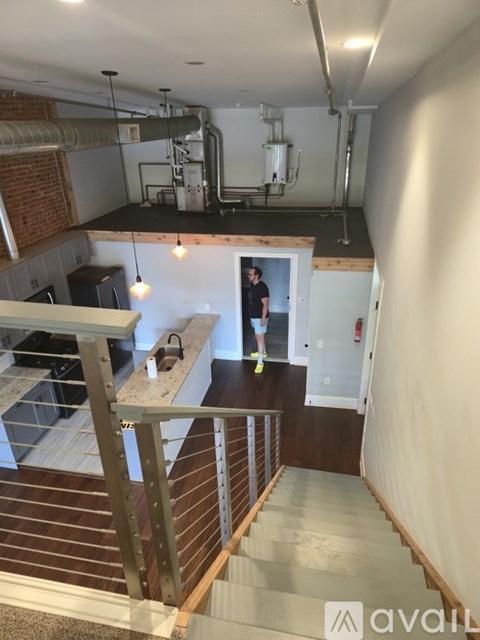 A man is standing in a doorway in a room with a staircase.
