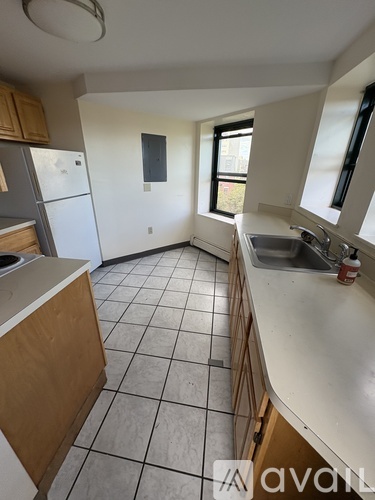 A kitchen with white appliances and wooden cabinets.