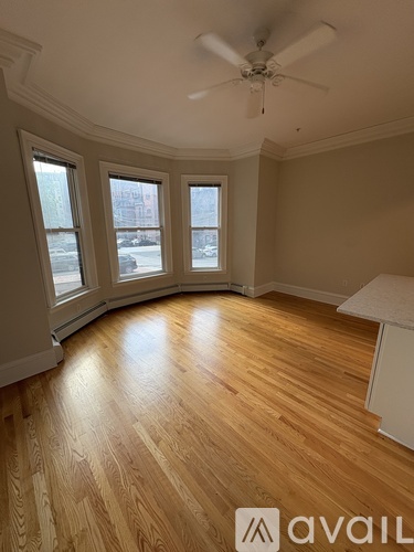 A room with wooden floors and a ceiling fan.