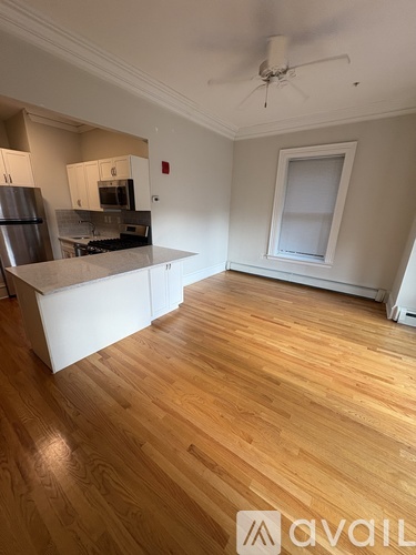 A kitchen with wooden floors and white walls.