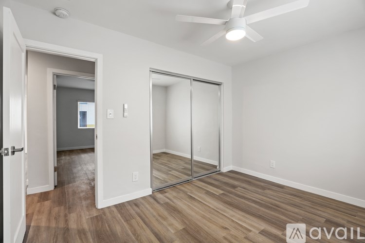 A modern house with a white fence and a garden in front.