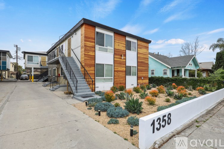 A modern house with a wooden exterior is numbered 1358 and is for sale.