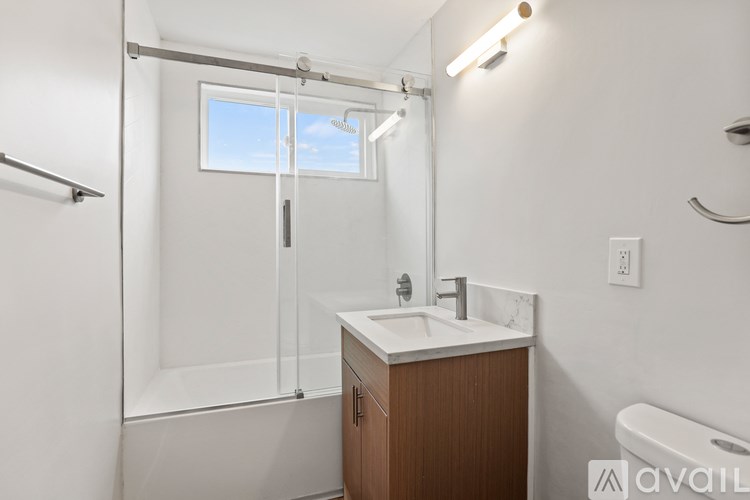 A bathroom with a white sink and a window.