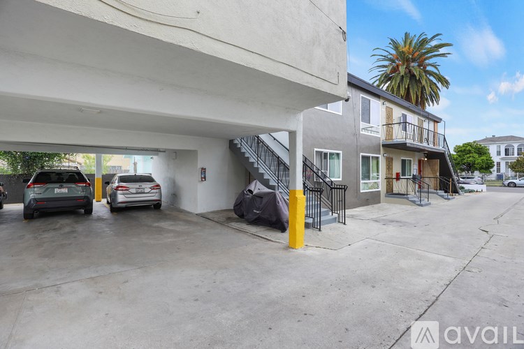 A parking garage with cars parked and a building in the background.