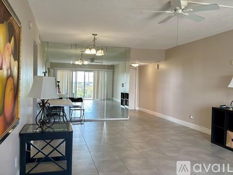 A living room with a ceiling fan and a painting on the wall.