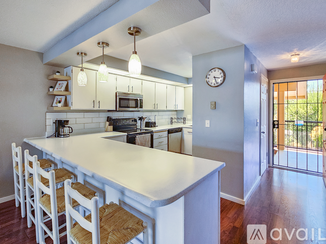 A kitchen with a white island and bar stools.