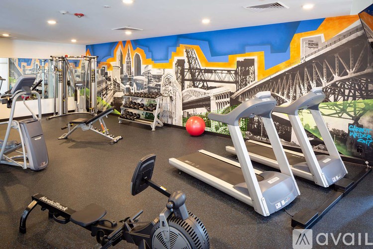 A gym with a variety of equipment including treadmills, weights, and exercise machines.