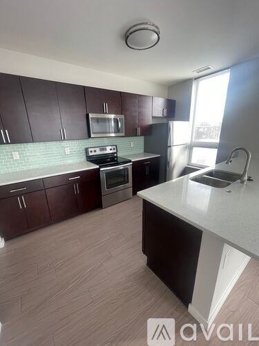 A kitchen with dark brown cabinets and a white counter.
