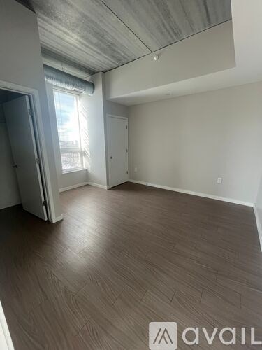 A room with wooden flooring and a ceiling with exposed beams.