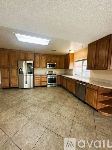 A kitchen with wooden cabinets and a tile floor.