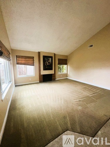 A room with a carpeted floor and a picture on the wall.