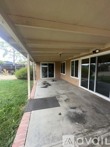 A patio with a black mat and a brick border.