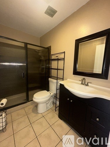 A bathroom with a toilet, sink, and shower.