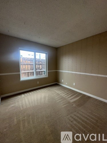 A room with a carpeted floor and a window.