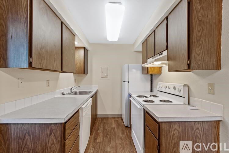 A kitchen with wooden cabinets and white appliances.