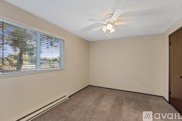 A room with a window and a ceiling fan.