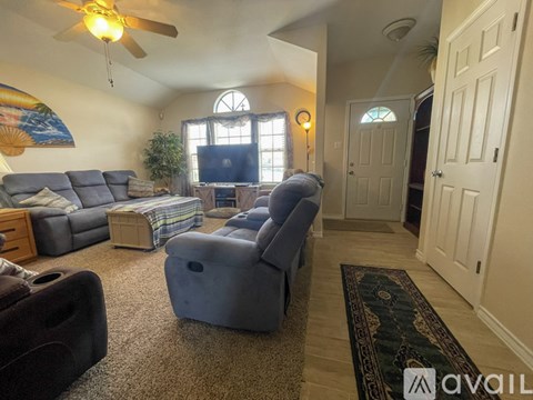 A living room with a grey sofa and a black chair.