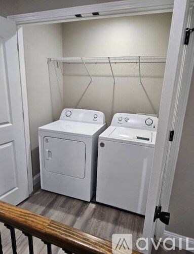 A small laundry room with two washers and a dryer.