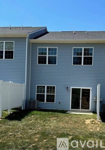A house with a blue siding and a white fence.