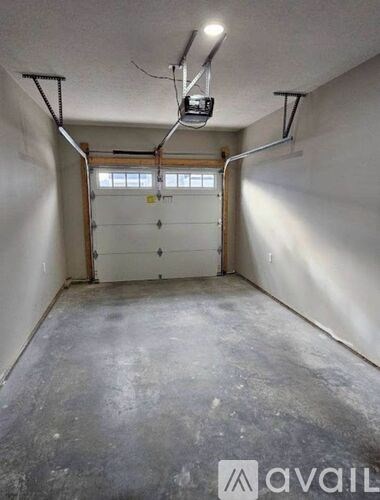 A garage with a concrete floor and a white wall.
