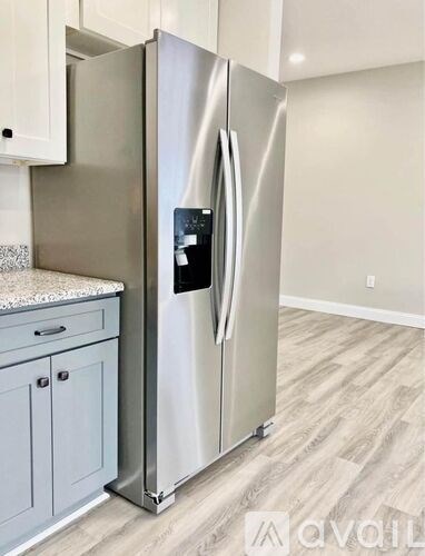 A stainless steel refrigerator with its door open in a kitchen.