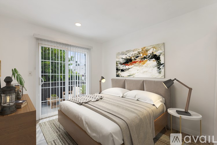 A bedroom with a large bed, a nightstand, and a painting on the wall.