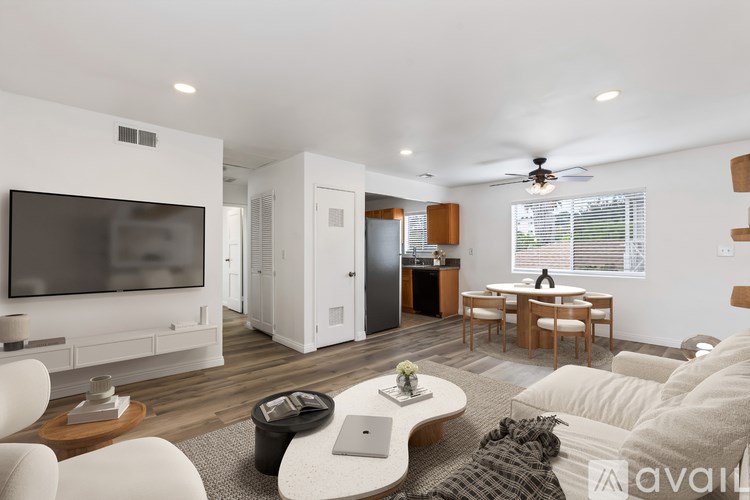 A modern living room with a television, sofas, and a coffee table.